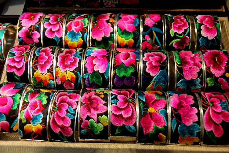 Miao hand-embroidered festival flower bangles in assorted tray display