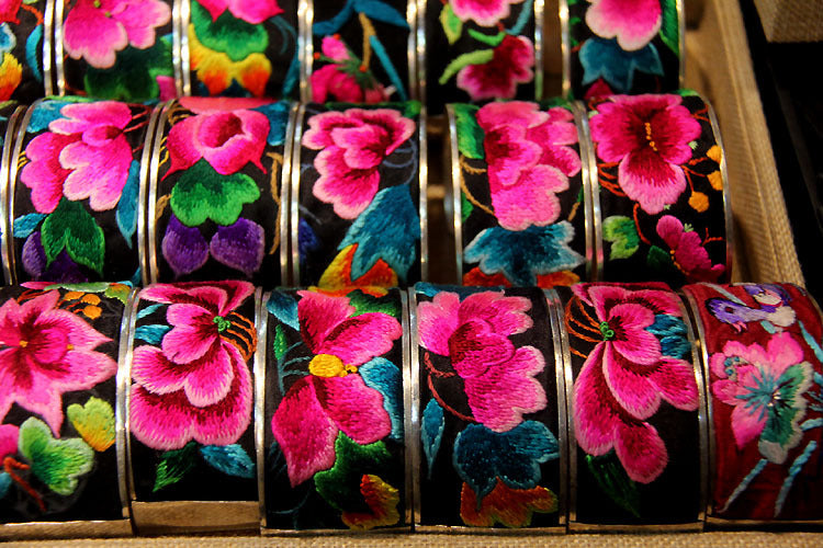 Close-up of Miao hand-embroidered floral bangles with pink flowers