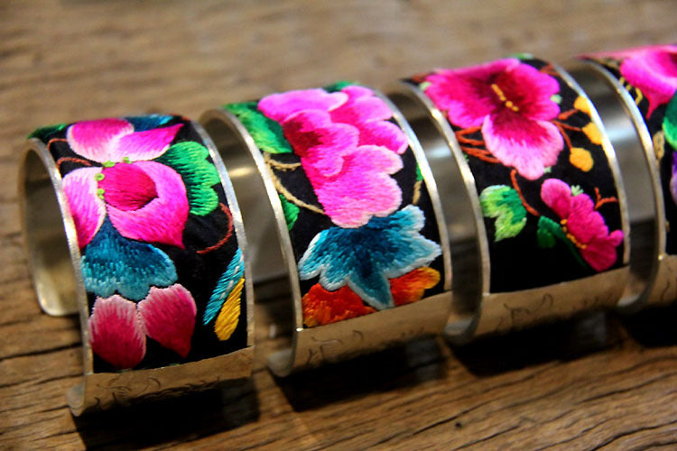Detail view of Miao hand-embroidered flower bangles with silver open cuff backs