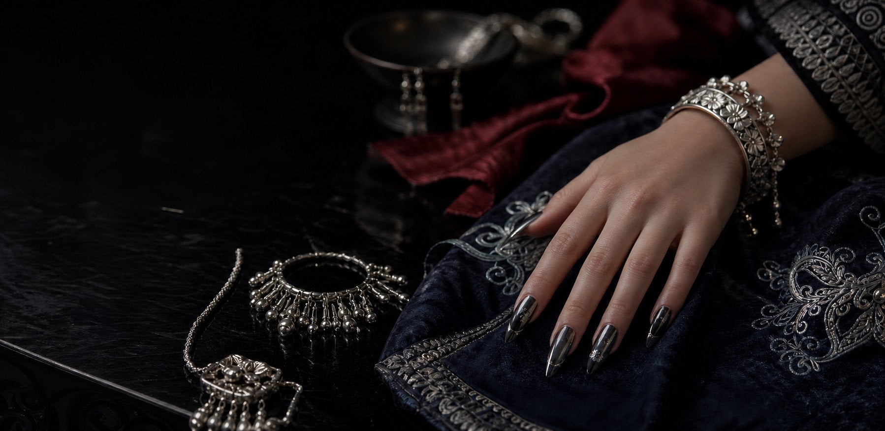 Miao silver jewelry inspired handmade press-on nails on dark embroidered fabric